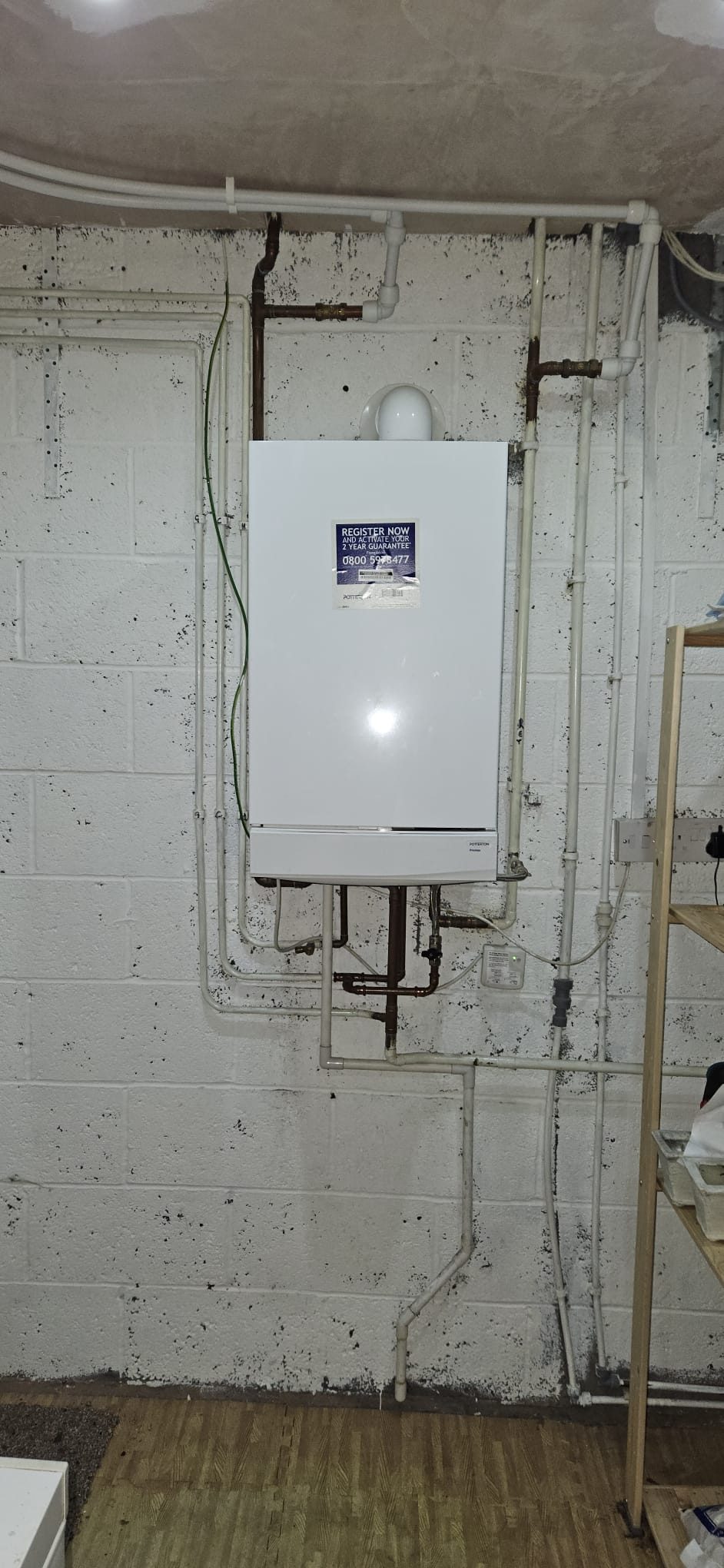 Boiler in basement with white pipework